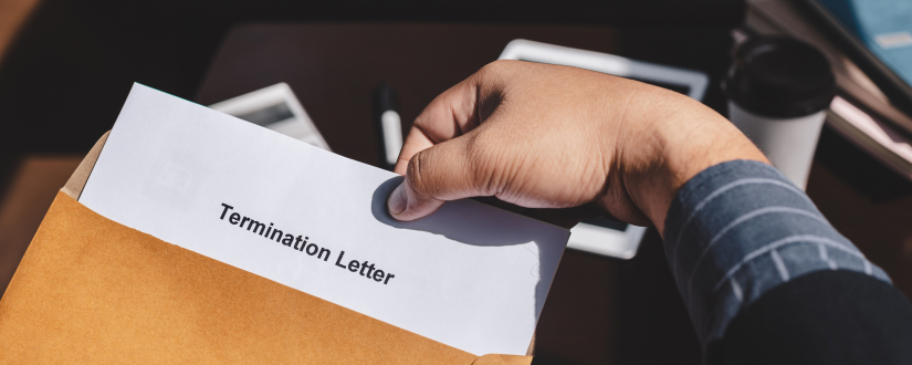 Two hands holding a crumpled piece of paper with the words 'Wrongful Termination' written in black, against a white background.