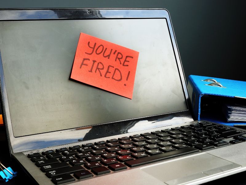 notebook with "you are fired" written on a sticky note